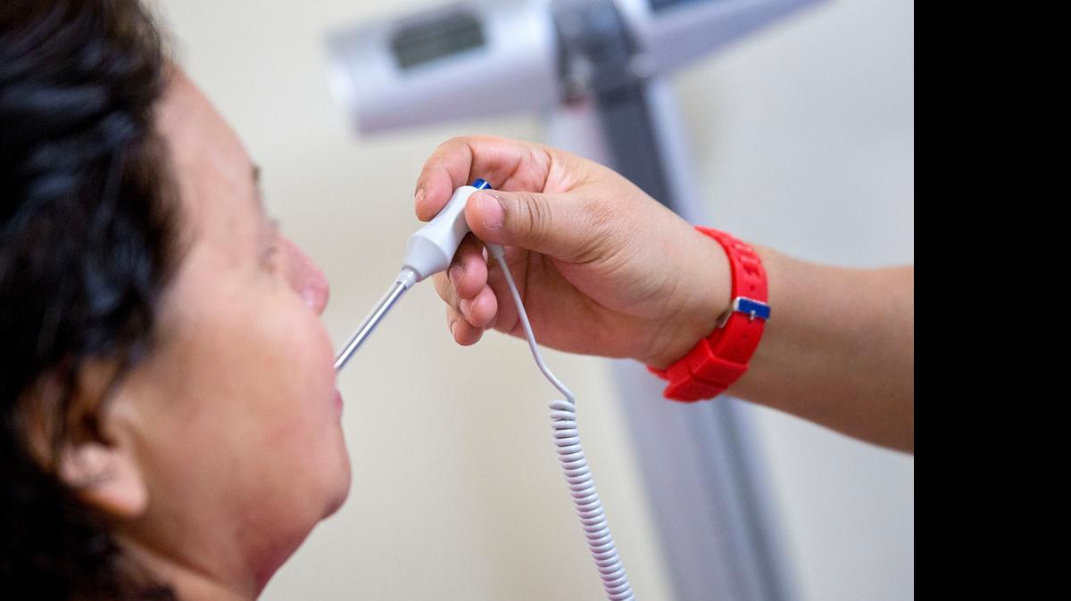 
A medical assistant takes a patient's temperature at a clinic in Silver Spring, Maryland.
