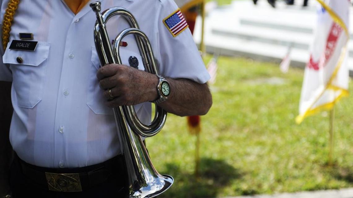 A veteran waits with bugle in hand for the start of the 2016 Memorial Day ceremony at Woodlawn Park Cemetery.