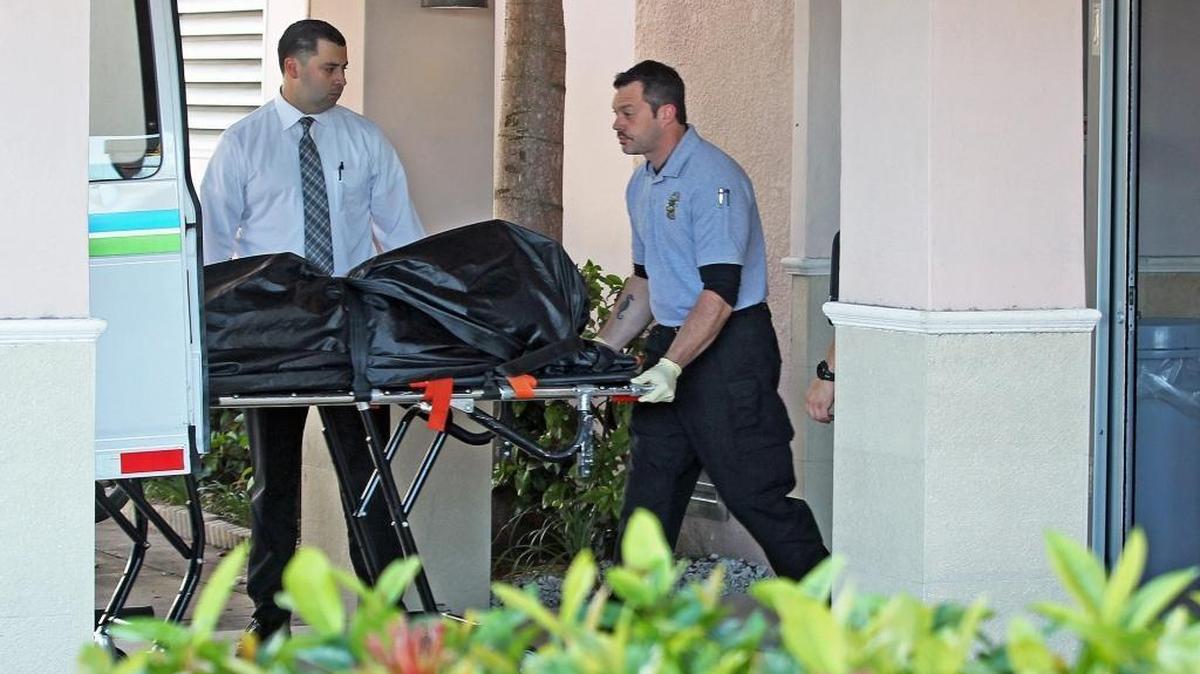 A Miami-Dade morgue official removes the body of a man who shot a woman then killed himself in the lobby of Kindred Hospital in Coral Gables on Monday, Jan. 4, 2016. The woman was taken to Jackson Memorial Hospital and is expected to survive.