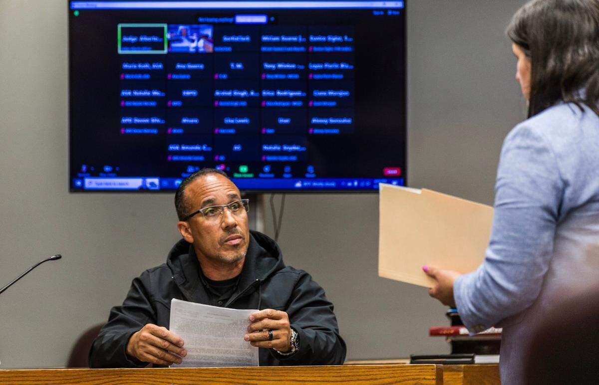 Defense attorney Beatriz Llorente hands some documents to Det. Fernando Carvajal as she cross-examines him during a pretrial hearing for defendant Oscar Olea at the Gerstein Justice Building in Miami on Thursday, March 7, 2024.