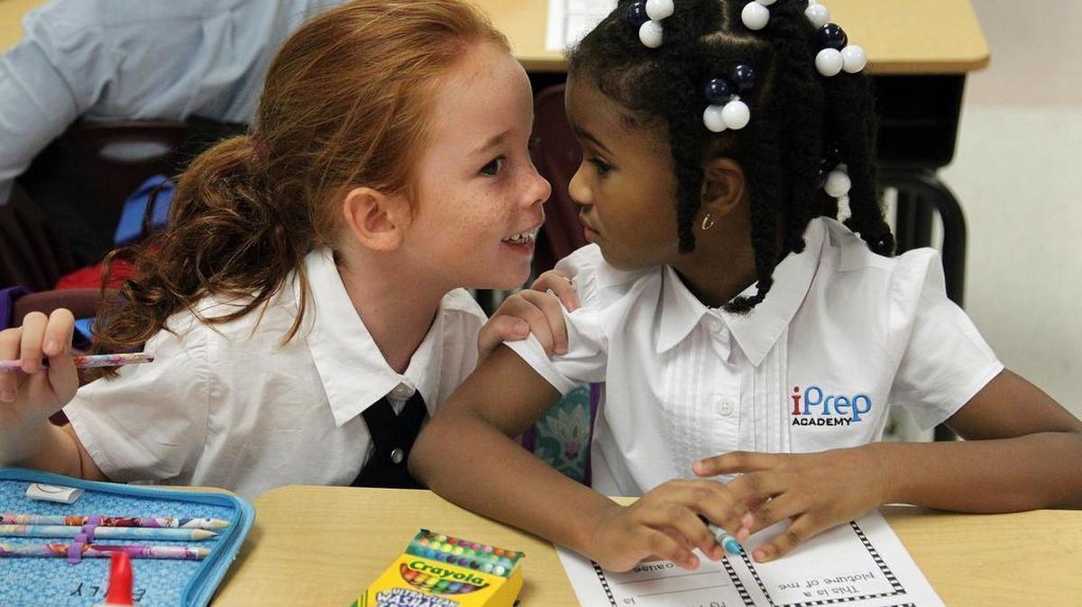 
First graders Emily Lund-Larsen, 6, left, and Lael Ponder, 6, share a conversation after being assigned seats next to one another on the first day of school on Monday, Aug. 24, 2015. Students attended the first day of school with pouts, smiles, and hugs at iPrep Academy.
