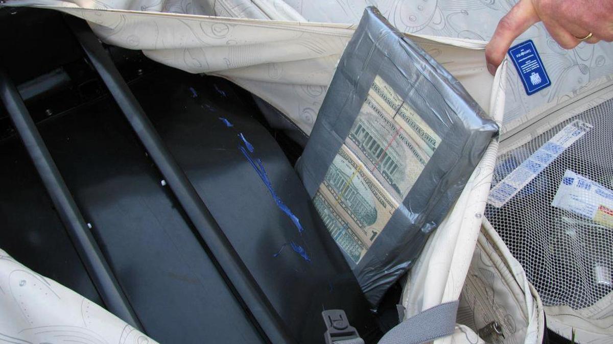 Agents found $2.4 million the luggage of two women traveling with a deportation officer.