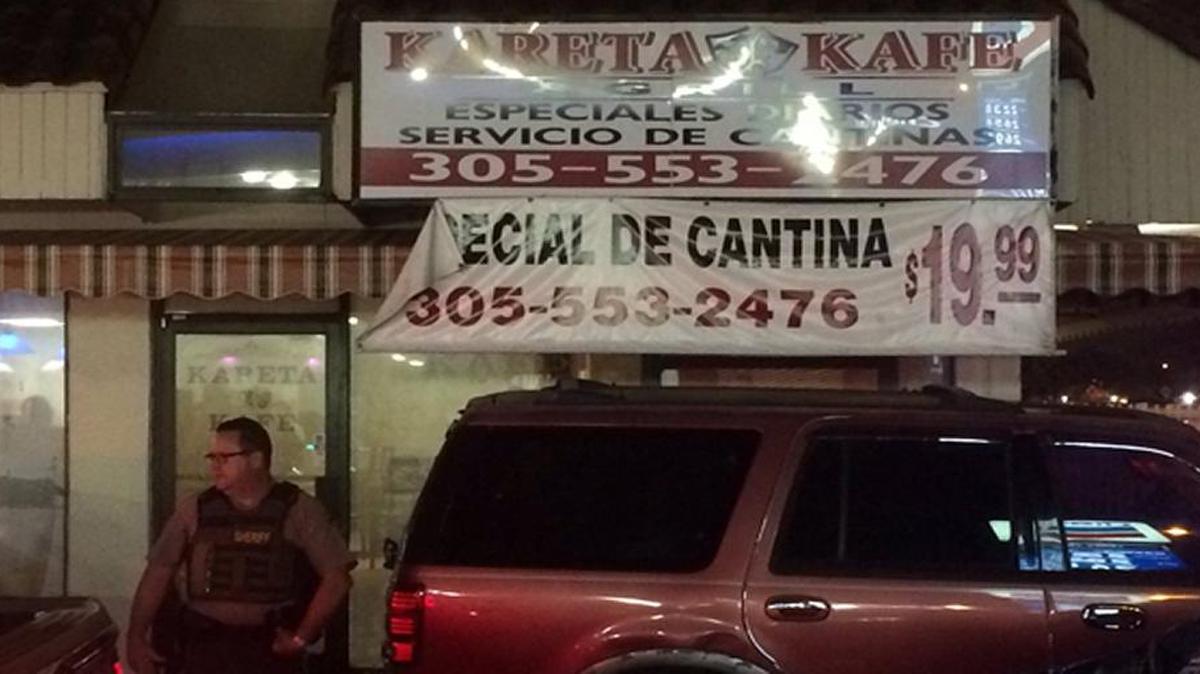A Miami-Dade police officer outside of Kareta Kafe, where police have busted a business on allegations of prostitution, gambling and drug dealing.