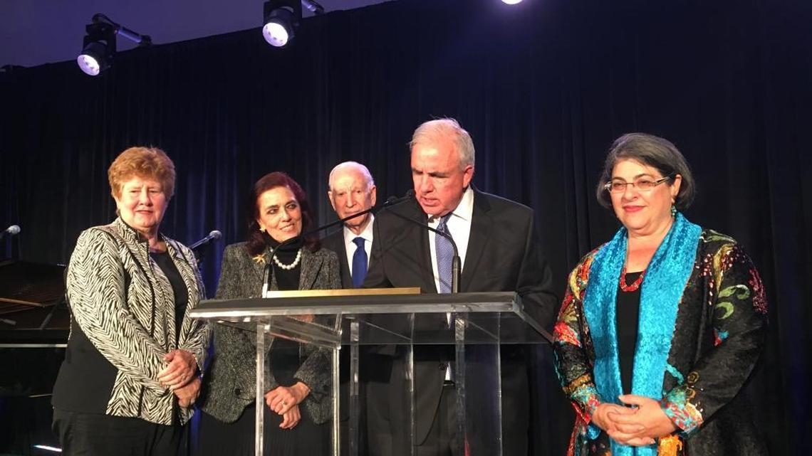 Miami-Dade Mayor Carlos Gimenez reads a proclamation honoring Patricia Frost (second from left) and Dr. Phillip Frost (third from left) at a Feb. 24 banquet by the Greater Miami Chamber of Commerce. The show of support came during the controversy over Gimenez’s proposed rescue of the science museum that bears the couple’s names. Flanking the stage are county commissioners Sally Heyman (left) and Daniella Levine Cava (right).