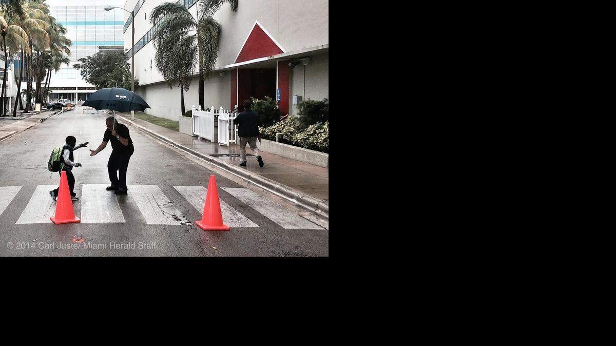 
Gray skies in South Florida on Monday morning can't stop Primary Learning Center's crossing guard from greeting students with a smile. 
