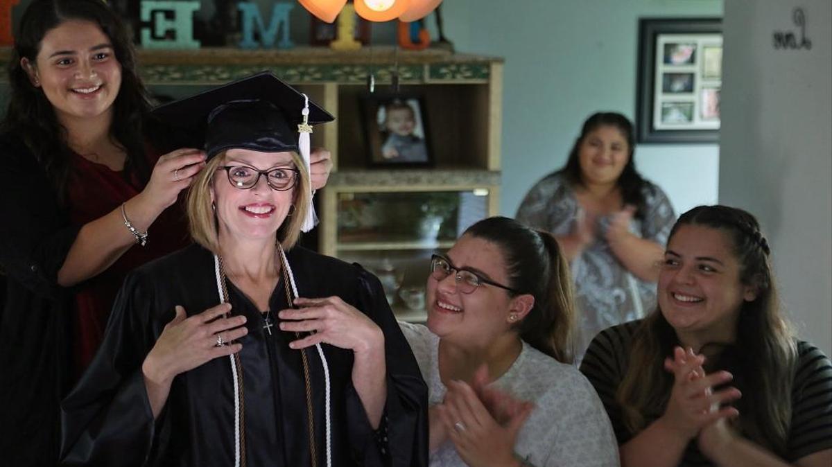 On Friday May 5, 2017 Gloria Jimenez, 53, mother of seven daughters, is photographed with her cap and gown with fellow Miami Dade College students who are also her children - Victoria, 24, left, Dominique, 19, Carla, 27, and Juliet, 22, on the left.