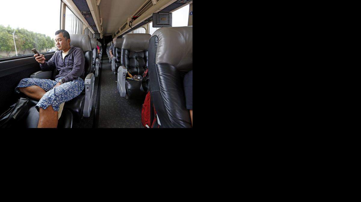 
Masahiko Tsuzura listens to music in his seat on the Red Coach as he travels to Orlando, Oct. 23, 2014. 
