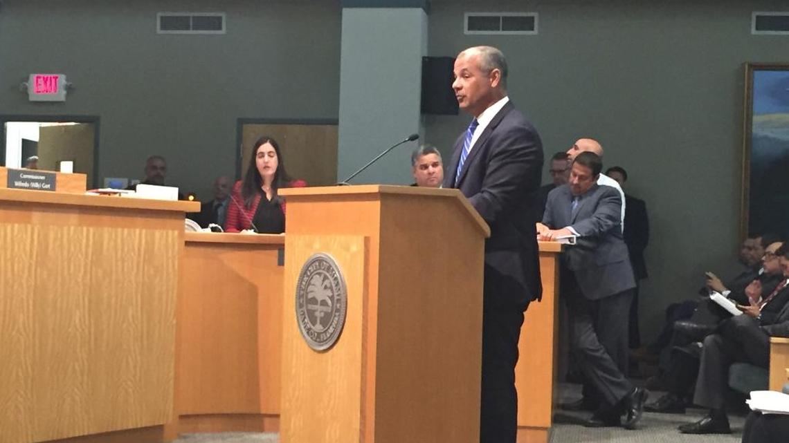 Attorney Javier Vazquez stands at a podium in Miami City Hall and defends himself and City Attorney Victoria Mendez (background).