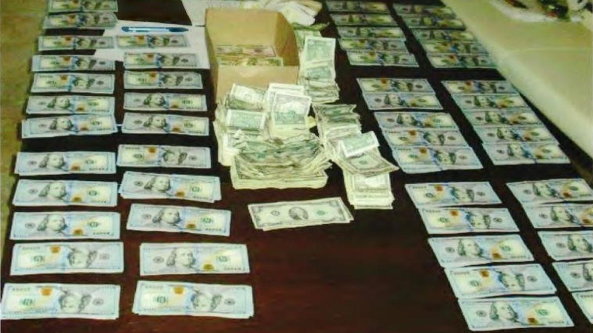 Some of the assets seized by federal agents when they arrested Jorge Lorenzo and his wife last week at their home in the 900 block of Southwest 94th Avenue, are shown in this photo released by the U.S. Attorney's Office. They found a safe containing $102,000 in cash, a painting by a prominent Cuban artist valued at $25,000, and dozens of Rolex and Cartier watches.
