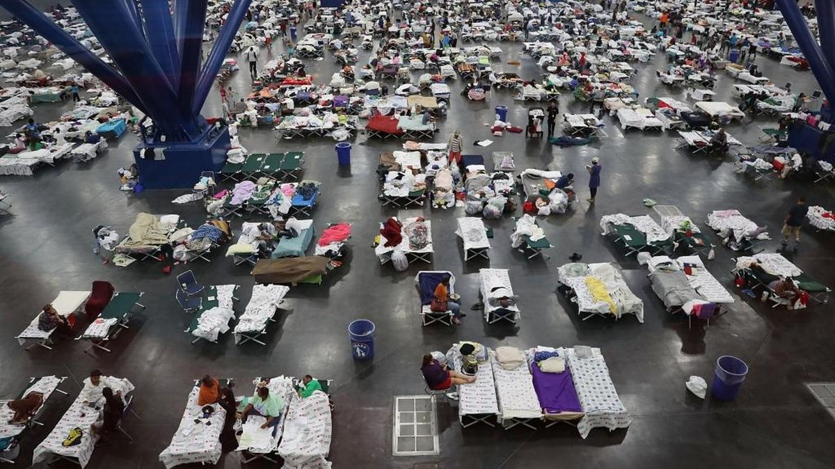 People take shelter at the George R. Brown Convention Center after flood waters from Hurricane Harvey inundated Houston Tuesday. The evacuation center, which is over capacity already, has received more than 9,000 evacuees with more arriving.