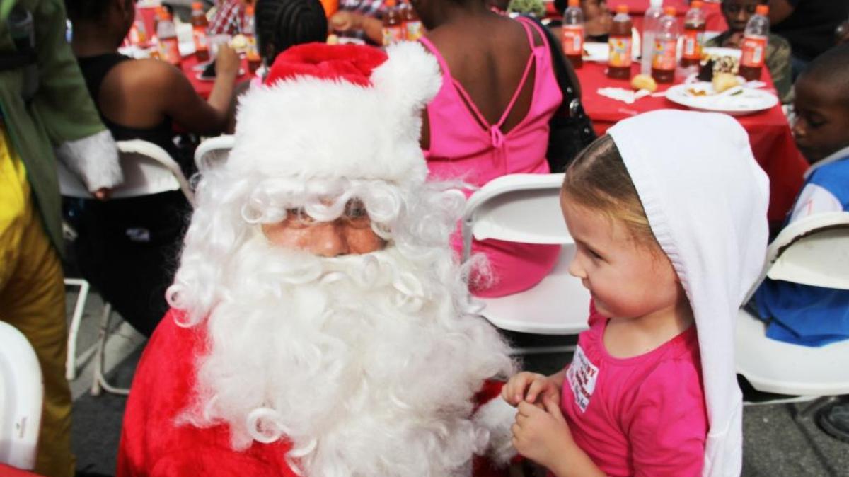 James Mickle, who dressed as Santa Claus, shares a moment Thursday with Gabriela Jankowicz at the Miami Rescue Mission in Miami.