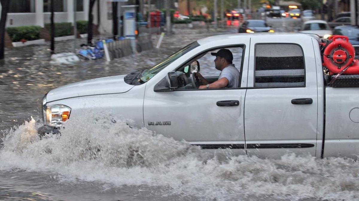 Cars goes through the flooded cause by heavy rains at Brickell area Aug. 1 in Miami.