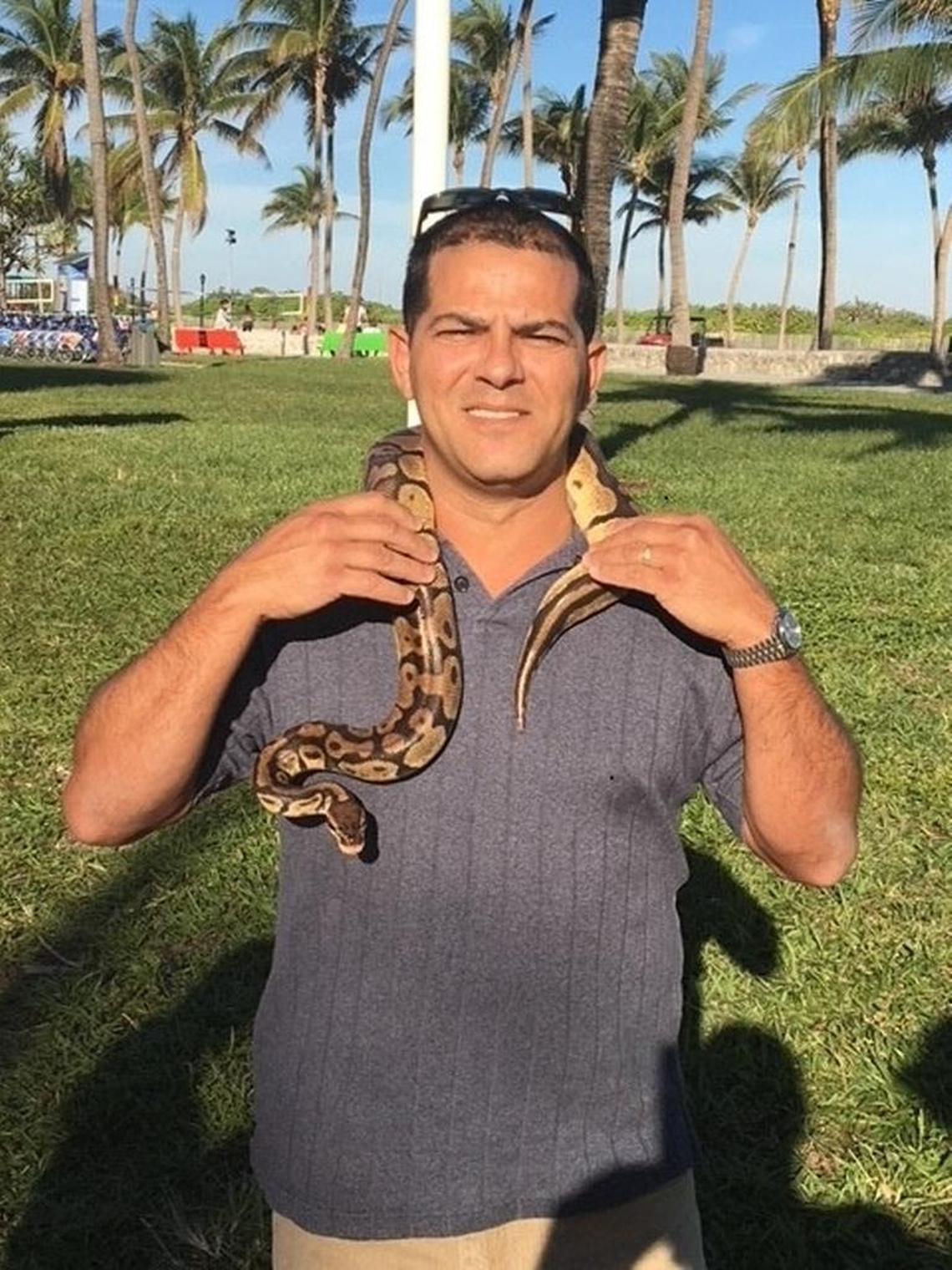 A Miami Beach code enforcement officer poses with Penelope the python in December 2017. State police soon detained the snake’s owner and called the border patrol when she could not produce documents showing she was in the United States legally.