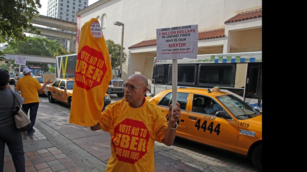 
Shalom Hamami, a taxi driver and owner in Broward and Miami-Dade, on Tuesday protests Uber's continuing presence in Miami-Dade.
