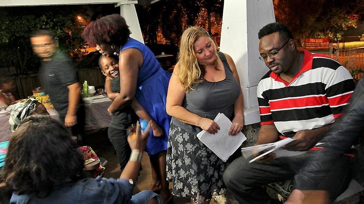 Susan Braun, center, chats with neighbor John Thompson III as they and some of their fellow Buena Vista Heights neighbors held a ‘porch party’ on Tuesday to discuss their opposition to a proposed parking garage in their neighborhood.
