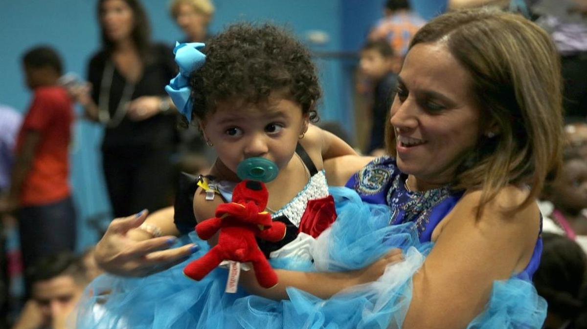 Grace Gonzalez holds her adopted 2-year-old daughter, Bella, during the National Adoption Day celebration Friday at the Miami Children's Museum.