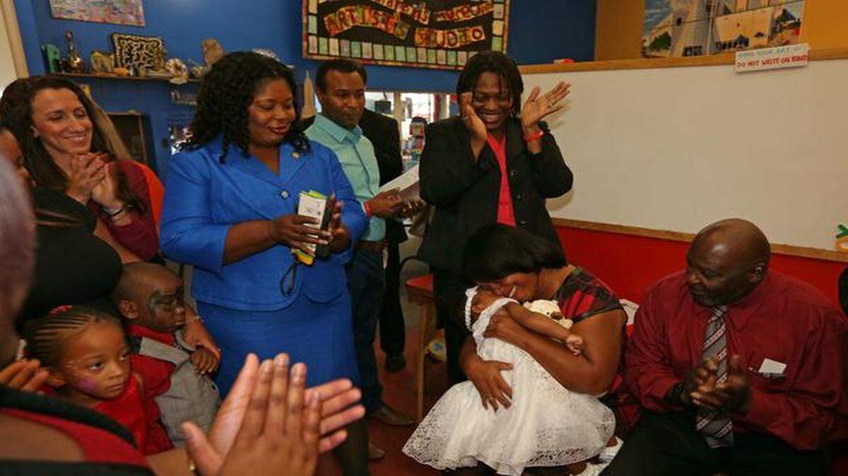 
Priscilla Walker, holds her newly adopted daughter, Faith Nieves Monestime, 20 months, while her family looks on, Friday, Nov. 22, 2013. The National Adoption Day event was held at the Miami Children's Museum.
