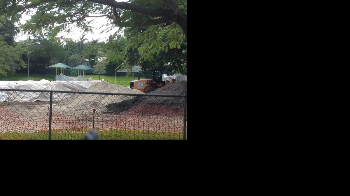 
Crews in backhoes work Monday around a mound of unearthed toxic soil covered by a white tarp in Merrie Christmas Park. City officials say they may work out a deal with Coral Gables to remove the contaminated soil rather than redistribute it in the park.
