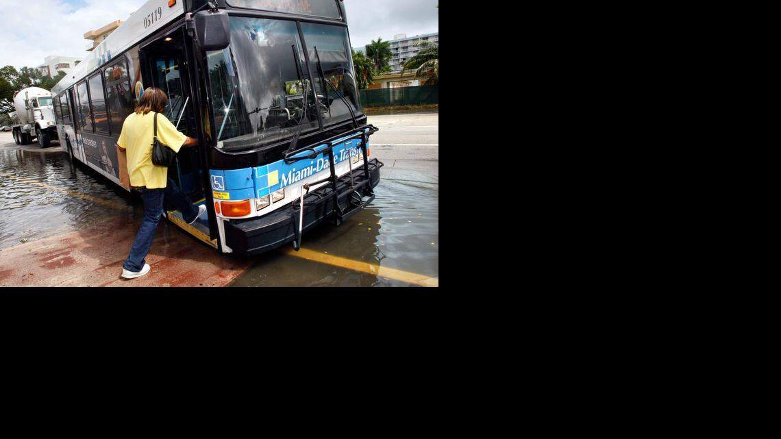 
A woman boards a Miami-Dade Transit bus on Alton Road at 10th Street in Miami Beach after the driver pulled up to a ramp, making it somewhat easier to avoid a huge puddle. 
