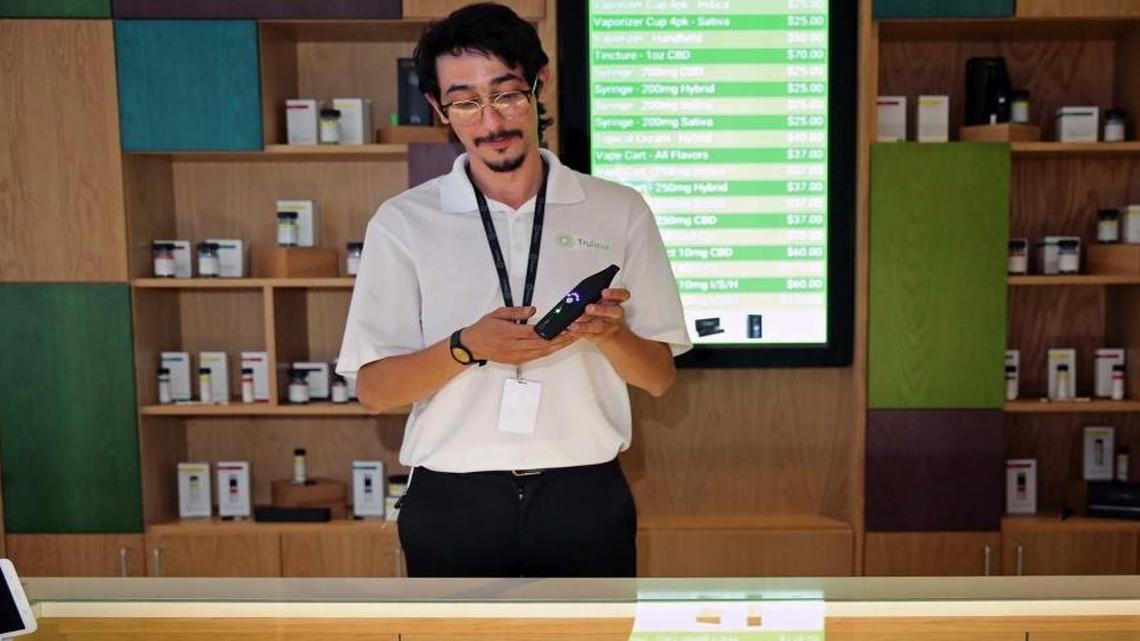 Andy Luis, a patient consultant at Trulieve, Miami's first retail medical marijuana dispensary, exhibits a vaporizer that can be used with cannabis products.