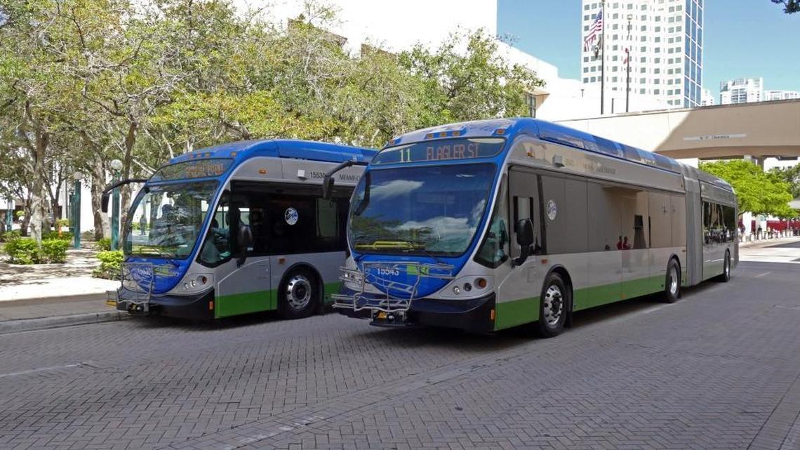 One of the new extra-long buses pulls away from the government center in dowtown Miami passing a staionary one after the formal unveiling on Monday.