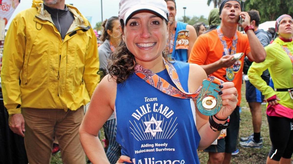 Rachel Schapiro, executive board member of Jewish Community Services of South Florida and runner for the JCS and Blue Card's Miami Marathon team, holds her medal after the race.