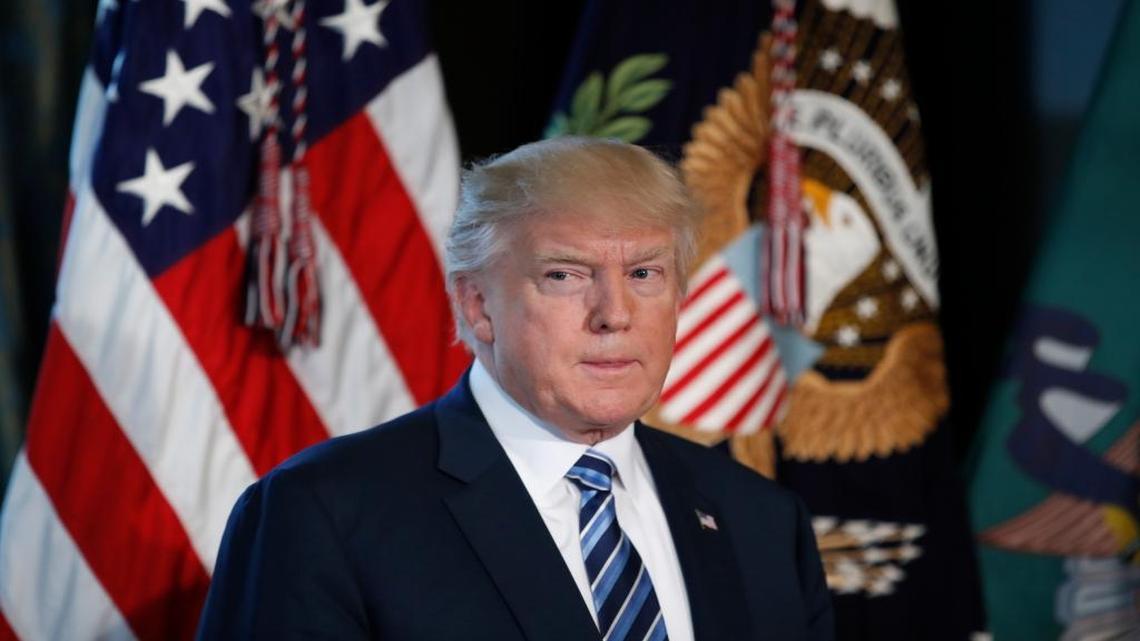 President Donald Trump listens as Treasury Secretary Steve Mnuchin speaks at the Treasury Department in Washington, Friday, April 21, 2017.