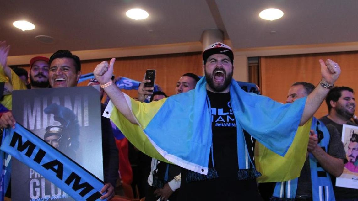 Attorney Jonathan J. Morhaim, right, a member of the Southern Legion soccer club could not hold back his enthusiasm during the announcement of the new Miami Major League Soccer team on Monday.
