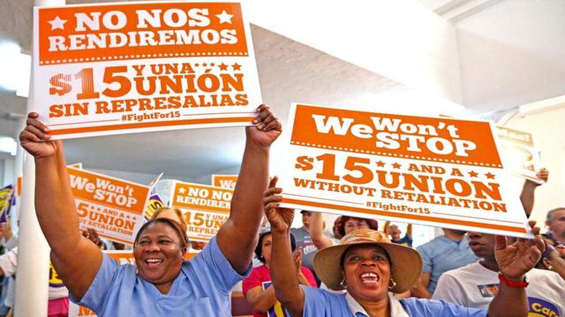 
Rita Breus and Ebeline Miteyer hold signs in support of raising the minimum wage at a rally at Greater Bethel AMF Church in Overtown, Miami, April 15, 2015. 
