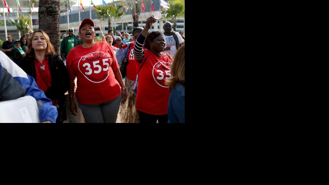 
Patricia Pierre, center, who said she makes $8.75 an hour plus tips, stands with other HMSHost workers and union representatives as Unite Here Local 355 threatens a strike at the Miami International Airport.
