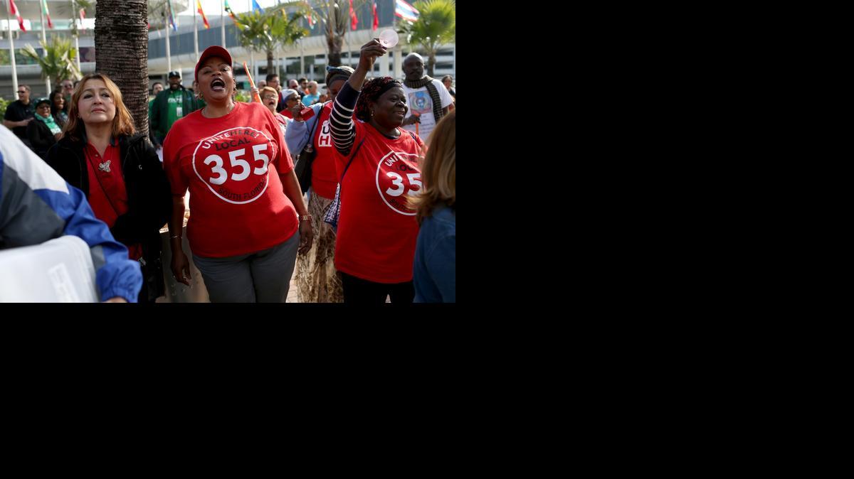 
Patricia Pierre, center, who said she makes $8.75 an hour plus tips, stands with other HMSHost workers and union representatives as Unite Here Local 355 threatens a strike at the Miami International Airport.
