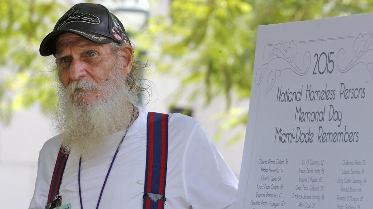 Formerly homeless and veteran Charles Mogoffin stands next to the sign with the names of deceased homeless people while speakers address the crowd on Dec. 18, 2015. Miami-Dade County joined more than 150 cities nationwide in hosting a "National Homeless Persons' Memorial Day" event and memorial service at the fountain at the west side of the Stephen P. Clark Center.
