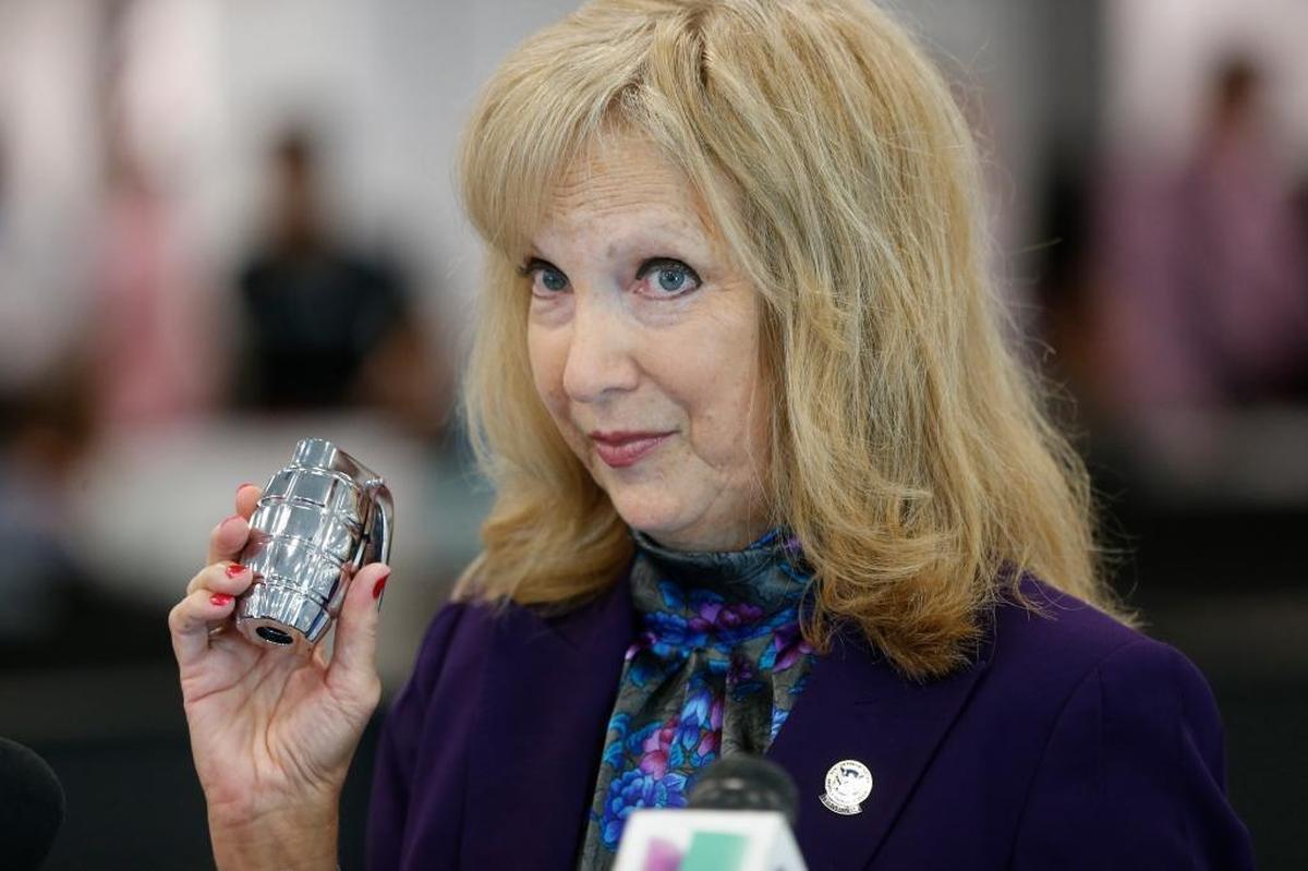 TSA Public Affairs Manager Sari Koshetz holds up a fake hand grenade that was found in a passenger’s carry-on luggage recently at Miami International Airport, as she speaks during a news conference on how travelers can prepare to get through airport screenings faster during the busy summer travel season.