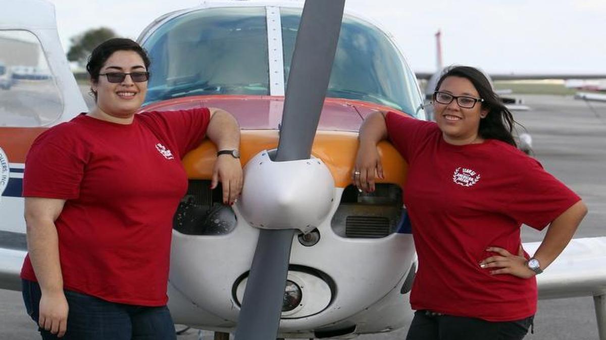 
Odanys Velazquez and Sandy Gonzalez pose for a photo before taking off from Miami Executive Airport for a cross-country race with their team shirts on Tuesday June 16, 2015.

