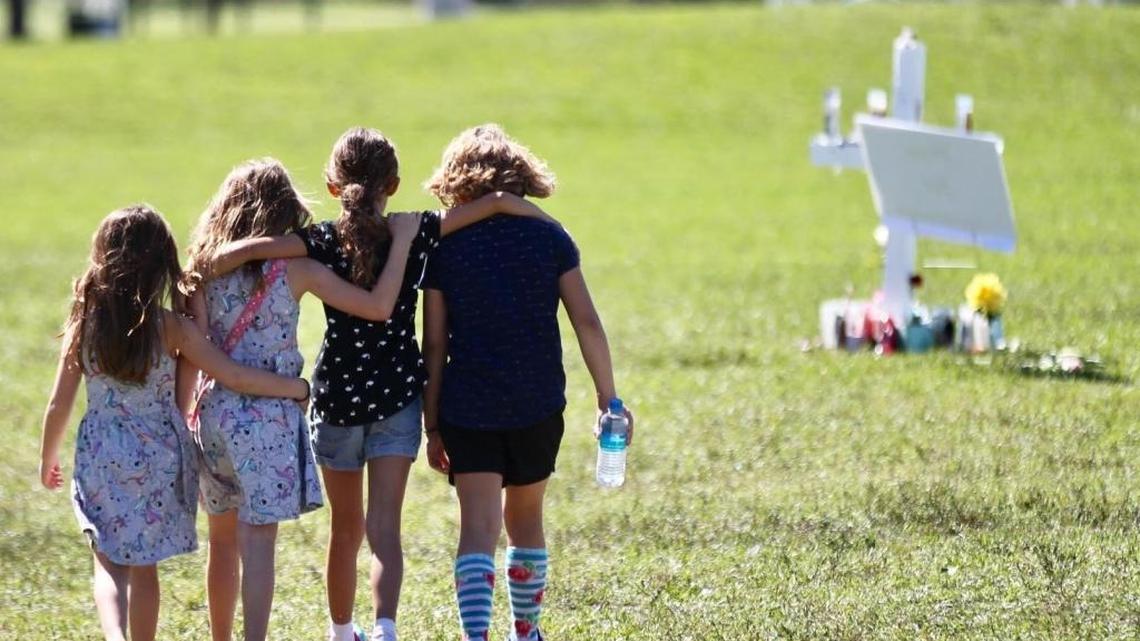 Four children with hands around each other approach a vigil post at Pine Trails Park in Parkland on Thursday, Feb. 15, 2018, honoring the 17 people who were shot and killed at Marjory Stoneman Douglas High School on Wednesday, Feb. 14, 2018.