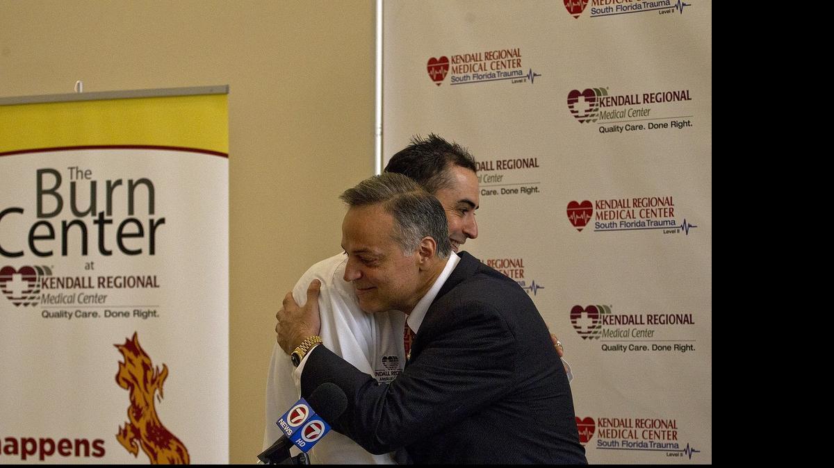 
Burn victim John Herrera gets a hug from his surgeon Carlos Medina after discussing an accident while he was igniting his home barbecue.
