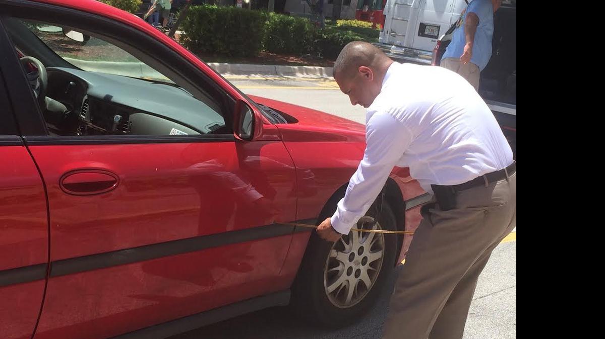 
Miami-Dade Det. Alvaro Zabaleta shows off a bullet hole in an unmarked police car Thursday. Police say Edward Lamar Greggs shot at the officers who were in the area of Northwest 119th Street and Second Avenue after Greggs was identified as a suspect in an attempted murder case from earlier in the week..
