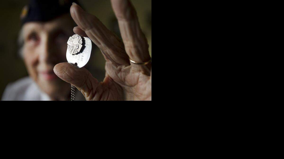 
Clara Hagerty, 91, holding her dog tag and her St. Christopher medal that she wore during the war, at her Miami home on Thursday, Dec. 4, 2014. Clara is a former Coast Guard Chief of Transportation. For two years, two months and 17 days, she worked as a driver transporting captains, ensigns, and officers. Sometimes, she would often be one of the last people on base to see the men before they went overseas.
