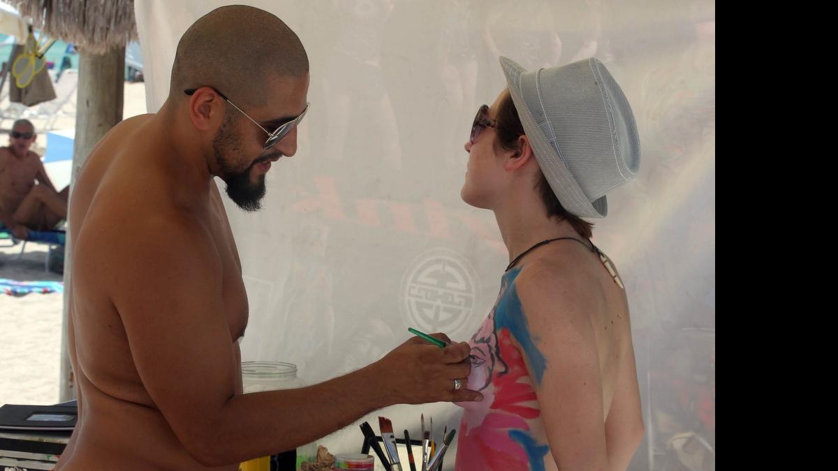 
Jeff Simon, left, body paints Caity Simon, along with others attending the South Florida Free Beaches Foundation 24th anniversary party for the clothing-optional section of Haulover Beach, Saturday, July 11, 2015.
