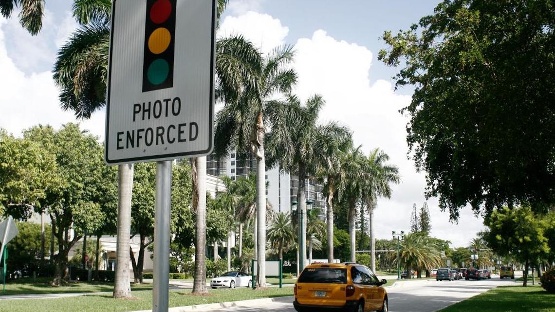 A sign warns drivers of red-light cameras at the intersection of West Country Club Drive and Aventura Boulevard in August 2009.