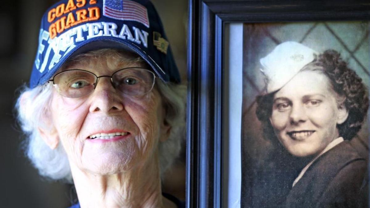 Clara Green 90, holds a photograph of herself in her U.S. Coast Guard uniform during World War II.