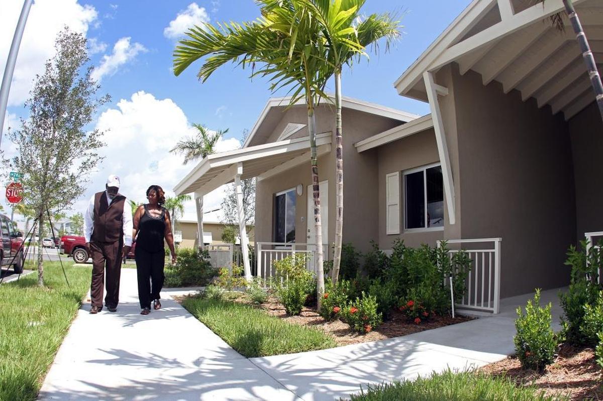 Husband and wife Timothy and Deborah Drayton, formerly homeless with their family, walk outside their new home as the Miami-Dade County Homeless Trust and Carrfour Supportive Housing host the grand-opening of the newly-built Verde Gardens townhouse community on Wednesday, Sept. 7, 2011.