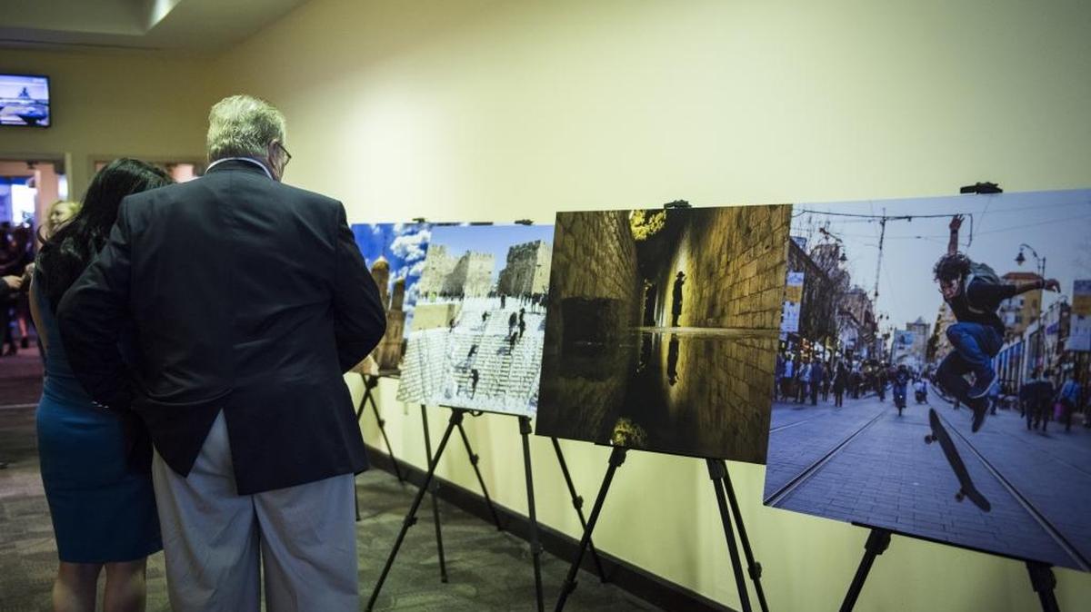 Attendees look at the gallery of photos from around Israel displayed during Israel's 69th Independence Reception on Sunday, May 21, 2017, at FIU's Biscayne Campus.