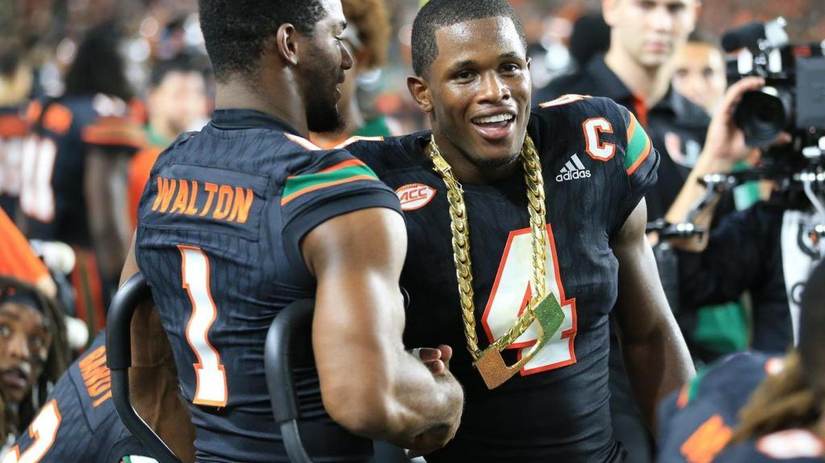 Miami Hurricanes running back Mark Walton (1) congratulates defensive back Jaquan Johnson (4) after receiving the turnover chain as the University of Miami hosted the Virginia Tech Hokies at Hard Rock Stadium on Nov. 4, 2017.