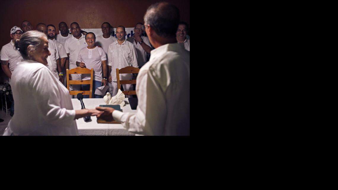 
Founders of Church of Babalú Ayé, Carmen Rodriguez, left, and son, Ernesto Pichardo, right, hold hands as Pichardo announces the unification of his church with Kola Ifa Miami. Ceremony organizers say the partnership is aimed at making Miami and Cuban's Lukumi, or Santeria, community more mainstream and less mysterious to the public and to differentiate the faith from back-to-Africa practitioners.
