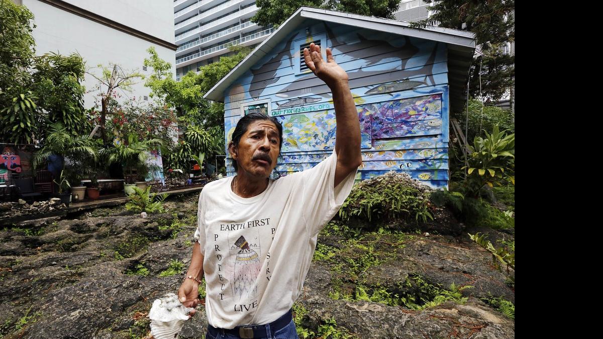 
Miami, April 28, 2015 - Ishmael lives in this house along with his father and the artist Burke Keogh. The house is located at 87 SW 11th St. and is mostly surrounded by high rise luxury buildings. Ishmael gestures as he explains how natives used a conch shell to signal each other as to the comings and goings of the Europeans who settled in this area and tried to enslave them. Ishmael has been digging on the site for years and he claims that the site is an ancient holy site dating back to the native tribes that inhabited this area before Europeans set foot in the Americas.
