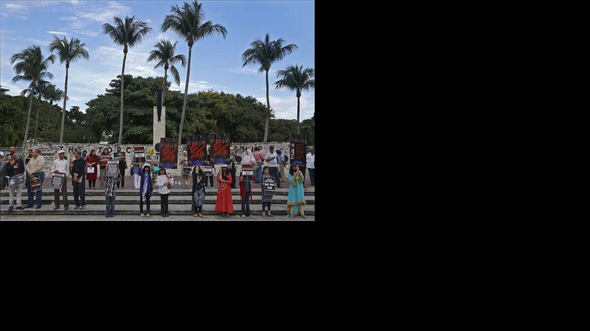 
IN PEACE: Members of the South Florida Pakistani community and others gather at the Torch of Friendship in Miami on Sunday for a vigil to honor the 148 students and adults who were killed Tuesday by the Taliban at a school in Peshawar, Pakistan. 
