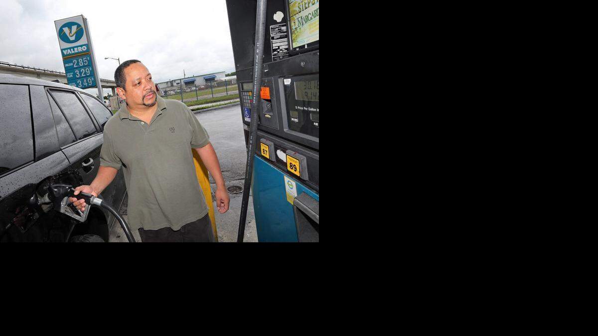 
FILE--Commuter Jose Collazo pumps gasoline at Valero on NW 27th Ave. and 71st Street in Miami. With the holidays approaching, people say spending less money at the pump means more money for trips and gifts.
