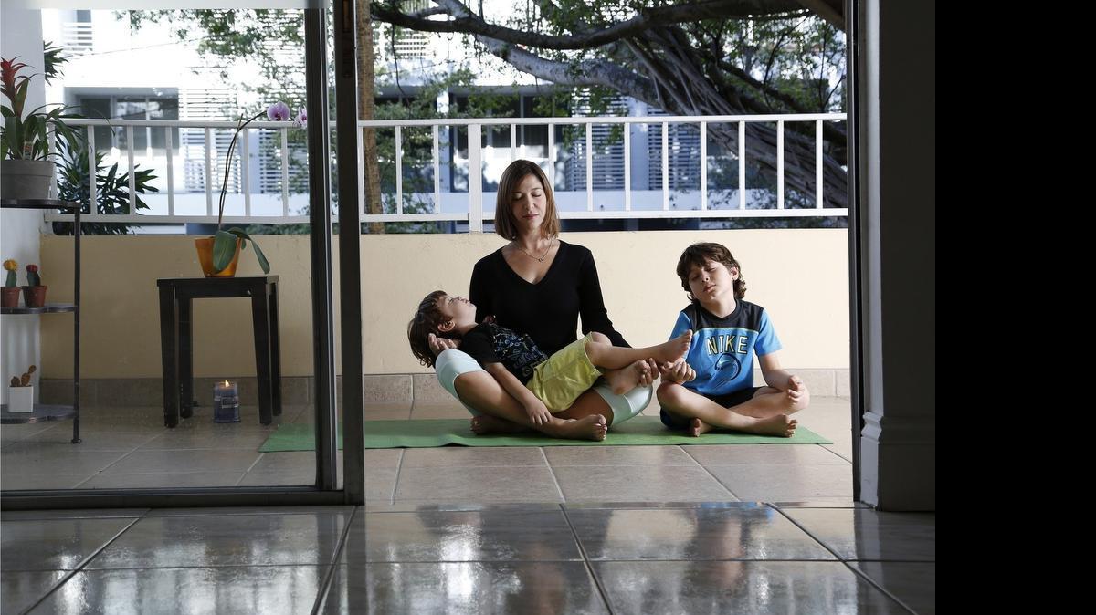 
YOGA HOME: Sabina Covo make times for yoga in her daily life at her Coconut Grove condo. Joining her are her two children, Paulo, 2, left, and Pedro, 6, right.
