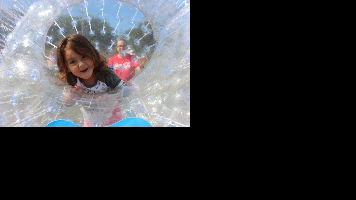 
Emily Chao, 2, rode in a giant clear plastic bubble during a family field day hosted by Coca-Cola on Dec. 13, 2014 in Shenandoah Park. Recently, the city of Miami was given $200,000 by the refreshment company to expand the park’s playground, build an outdoor fitness equipment area and upgrade its tennis courts.

